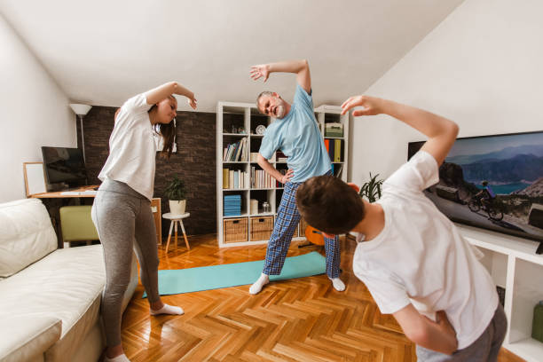 istock Healthy morning stretching - man with kids doing gymnastic exercise at home 1303300037