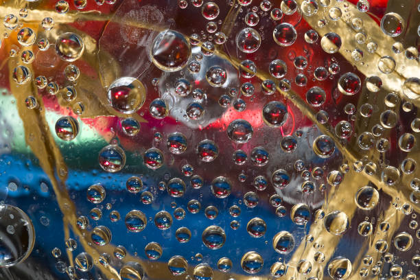 istock Multicolored spheres are located against a red-blue background with dry leaves located on it. 1303301336