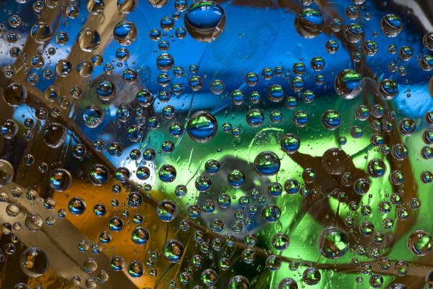 istock Transparent drops of water flow down on a multi-colored background with dry leaves located on it. 1303301346