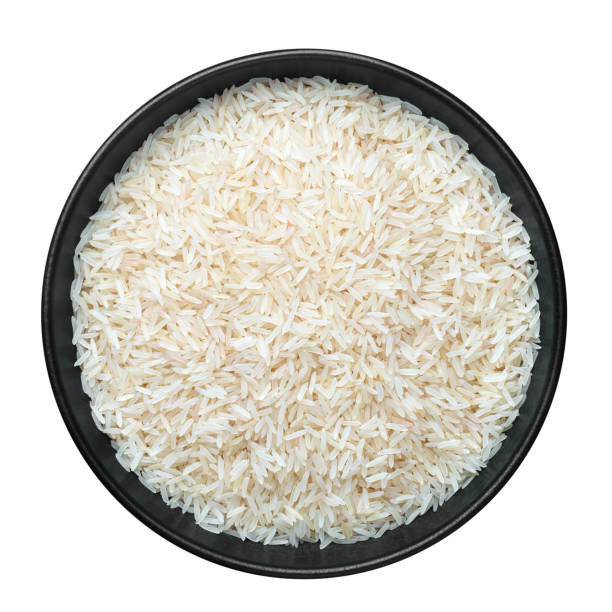 Raw long grain rice in black ceramic bowl isolated on white. Heap of uncooked basmati or jasmine rice. Healthy vegetarian organic food ingredient Raw long grain rice in black ceramic bowl isolated on white. Heap of uncooked basmati or jasmine rice. Healthy vegetarian organic food ingredient jasmine rice stock pictures, royalty-free photos & images