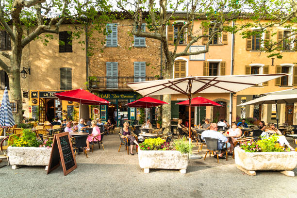 People enjoy a coffee or a drink on an outdoor terrace in the traditional tourtour village in Provence stock photo