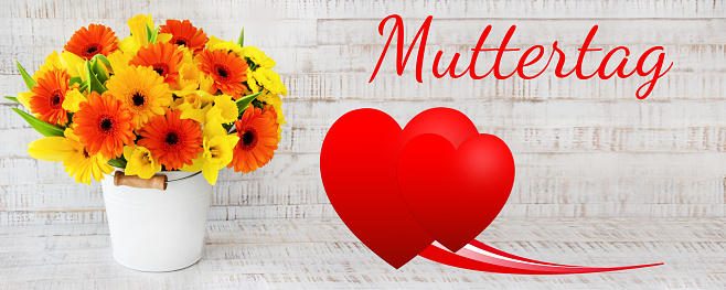 Mothers day gerberas and red hearts on wood background, banner
