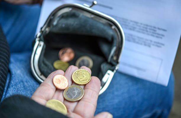 Poor elderly woman is counting some Euro and Cents coins in her hand while holding purse and dunning letter Debt and poverty concept, selective focus with little depth of field for adequate copyspace poverty stock pictures, royalty-free photos & images