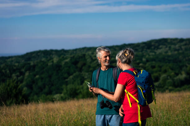 istock Active senior couple with backpacks hiking in nature. 1303306800