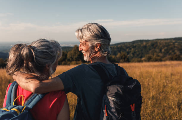istock Active senior couple with backpacks hiking in nature. 1303306904