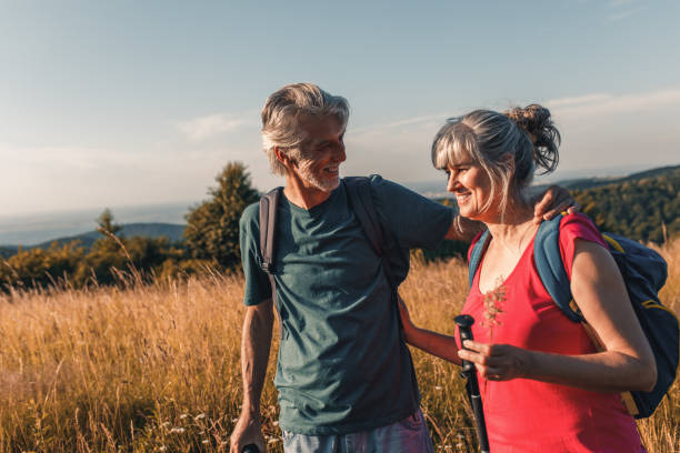 istock Active senior couple with backpacks hiking in nature. 1303306990