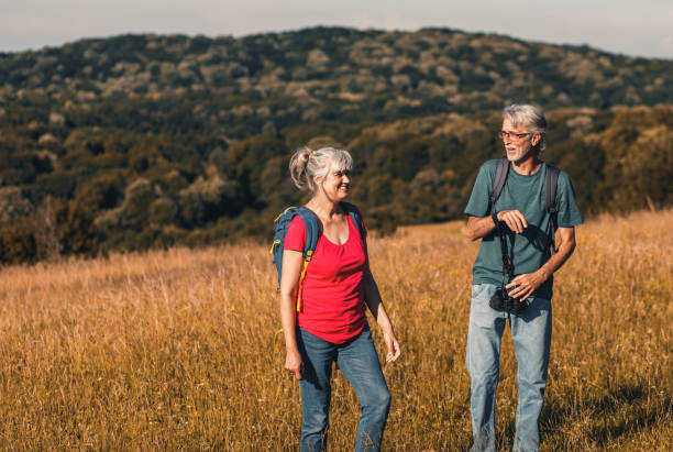 istock Active senior couple with backpacks hiking in nature. 1303307077