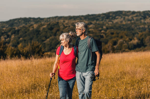 istock Active senior couple with backpacks hiking in nature. 1303307113