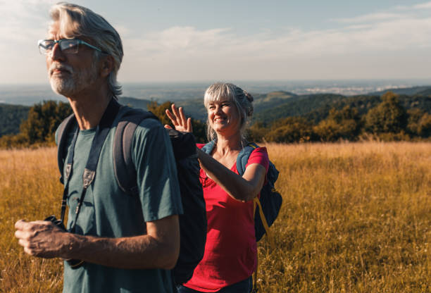 istock Active senior couple with backpacks hiking in nature. 1303307126