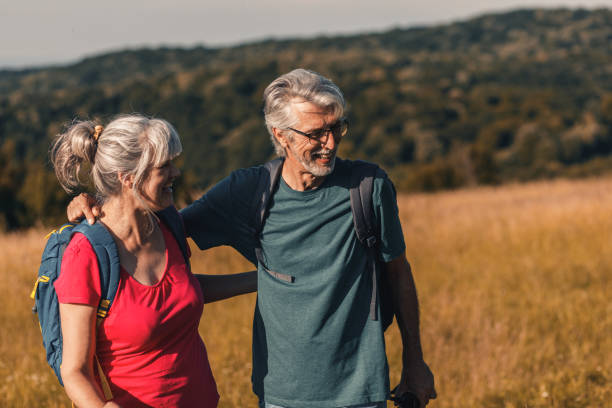 istock Active senior couple with backpacks hiking in nature. 1303307143