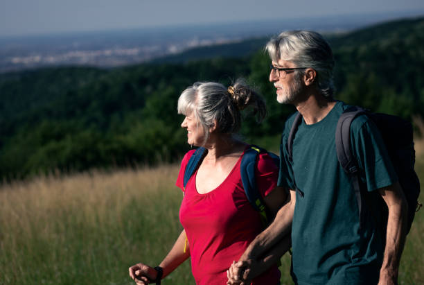 istock Active senior couple with backpacks hiking in nature. 1303307144