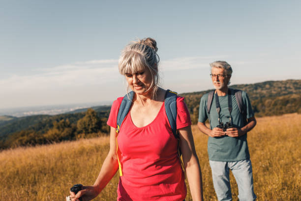 istock Active senior couple with backpacks hiking in nature. 1303307179