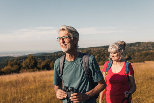 istock Active senior couple with backpacks hiking in nature. 1303307243