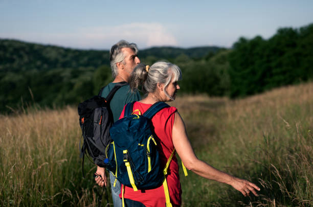 istock Active senior couple with backpacks hiking in nature. 1303307788