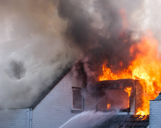 istock Heavy flames coming out of a white brick home that is on fire 1303309177