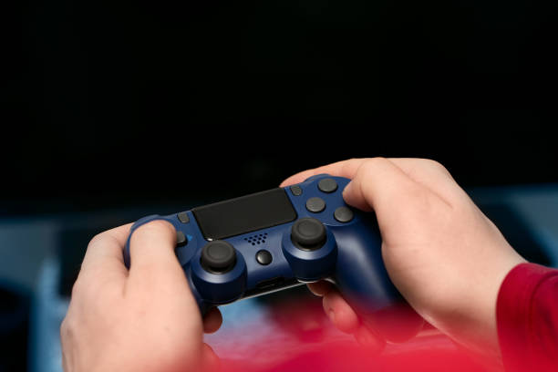 istock A man's hands hold a console controller in the foreground of the photo 1303310027