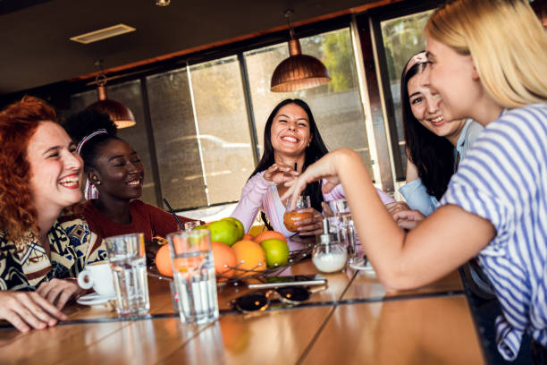istock Group of young female friends having fun in coffee shop, talking and laughing while sitting at table. 1303310607
