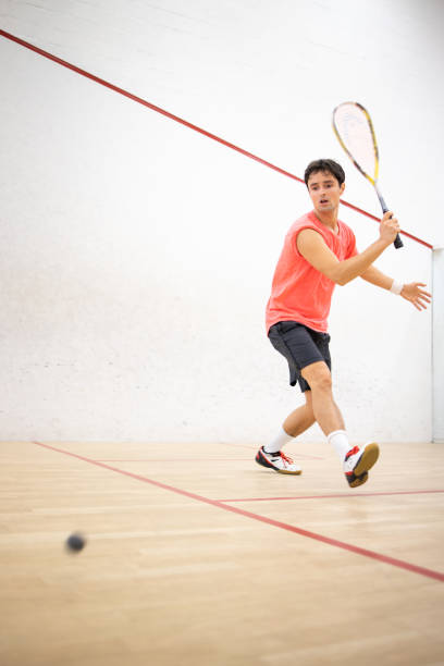 Squash player in action on a squash court Squash player in action on a squash court (motion blurred image; color toned image) squash sport stock pictures, royalty-free photos & images