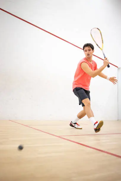 Photo of Squash player in action on a squash court