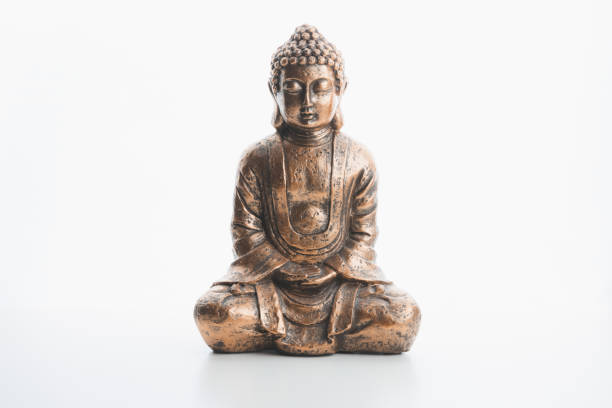 istock A bronze buddha indoor souvenir statue in lotus position isolated on a plain white background and surface. 1303317496