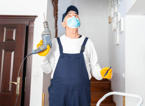 istock A senior worker with protective face mask drills a hole in the ceiling at home. Home restoration. 1303318445