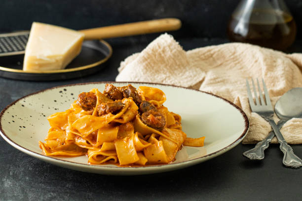 паста паппарделле с говяжьей колбасой и томатным соусом - pappardelle стоковые фото и изображения