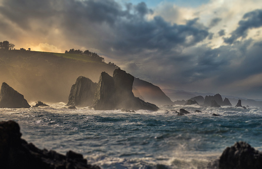 Horizontal shot of rocks in a Spanish coastline, idyllic landscape with rays of light