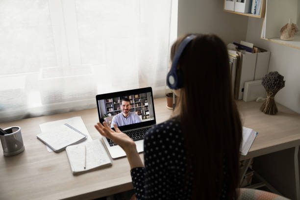istock Woman student in wireless headset communicating with tutor via videocall 1303320079