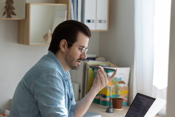 istock Concentrated young businessman freelancer dictating voice notes using phone recorder 1303320178