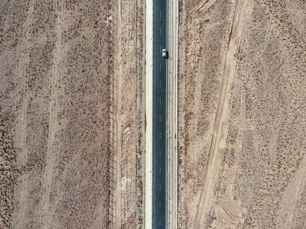 vista aérea da rodovia no deserto - arid climate asphalt barren blue - fotografias e filmes do acervo
