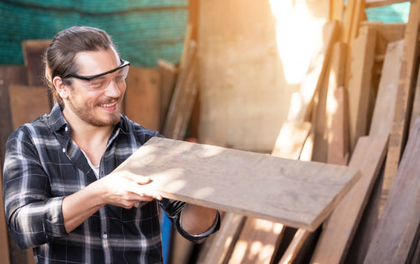 istock Carpenter work in wood workshop selecting timber for his woodwork 1303322296