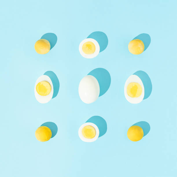 istock Boiled eggs with strong shadows symmetrically arranged against pastel blue background. Creative food concept. Flat lay. 1303323615