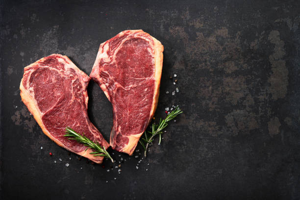 bistecche di costolette di manzo crude secche a forma di cuore (cote de boeuf) - meat beef love heart shape foto e immagini stock