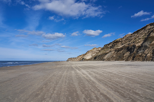 Beautiful coastline with sand dunes and blue sky near Nørre Lyngby in Denmark on a sunny day