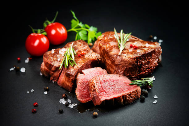 istock Grilled beef filet steaks with herbs and spices on dark slate 1303324768