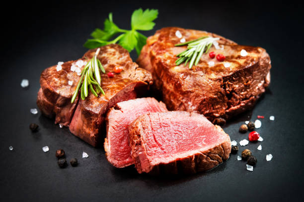 istock Grilled beef filet steaks with herbs and spices on dark slate 1303324769