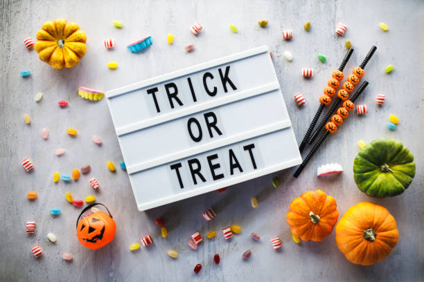 esplosione di caramelle di halloween, zucche e messaggio "dolcetto o scherzetto" su una bacheca - halloween candy immagine foto e immagini stock