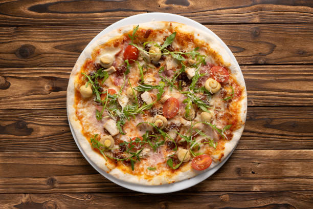 istock Pizza with bacon, chicken, mushrooms, arugula, tomatoes and mozzarella cheese 1303328792
