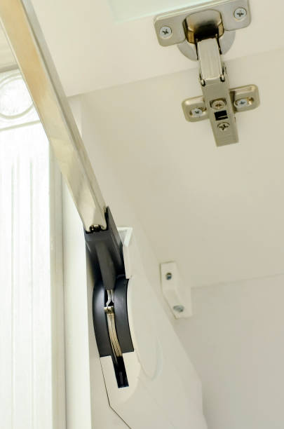 istock Kitchen front door lift pneumatic or gas support spring. Hardware for Kitchen Cabinets - Closeup detail. White kitchen furniture. 1303329468