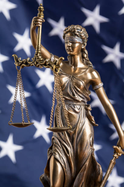 die statue der gerechtigkeit themis oder justitia, die mit verbundenen augen göttin der gerechtigkeit gegen eine flagge der vereinigten staaten von amerika, als rechtsbegriff - us constitution constitution usa government stock-fotos und bilder