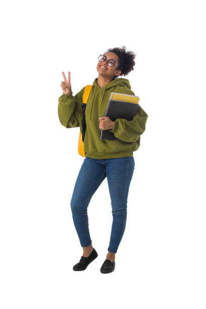 Friendly ethnic black female high school student in eyeglasses with backpack and composition book isolated on white background, full length portrait