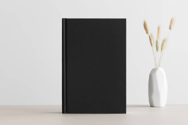 istock Black book mockup with a lagurus decoration on a beige table. 1303331457