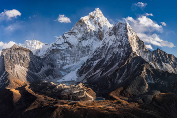 66MPix Panorama of beautiful  Mount Ama Dablam in  Himalayas, Nepal 66MPix XXXXL size panorama of Mount Ama Dablam - probably the most beautiful peak in Himalayas. 
 This panoramic landscape is an very high resolution multi-frame composite and is suitable for large scale printing
Ama Dablam is a mountain in the Himalaya range of eastern Nepal. The main peak is 6,812  metres, the lower western peak is 5,563 metres. Ama Dablam means  'Mother's neclace'; the long ridges on each side like the arms of a mother (ama) protecting  her child, and the hanging glacier thought of as the dablam, the traditional double-pendant  containing pictures of the gods, worn by Sherpa women. For several days, Ama Dablam dominates  the eastern sky for anyone trekking to Mount Everest basecamp icefall stock pictures, royalty-free photos & images