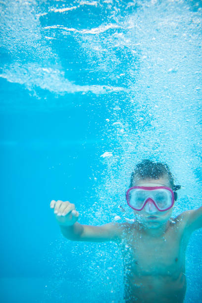 istock Cute little boy in a swimming pool 1303332754