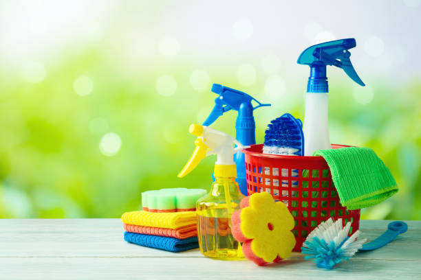 istock Spring cleaning concept with supplies on wooden table over beautiful spring bokeh background 1303335313