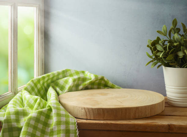 istock Empty wooden log board with tablecloth on wooden table over window and wall background. Spring and easter mock up for design. 1303335319