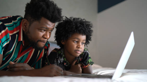 istock Father and son watching something on laptop at home 1303335428