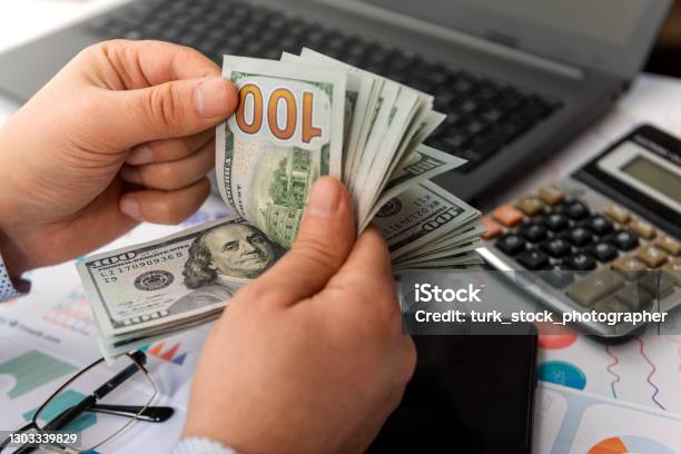 Businessman Counting Hundreds Of Dollars At His Table Stock Photo - Download Image Now