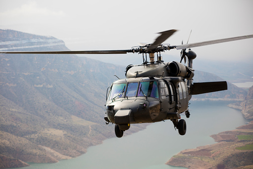 Military helicopter flying above a military base during a mission.