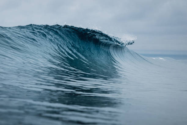 istock Perfect ocean waves with blue water cloudy sky. 1303342476